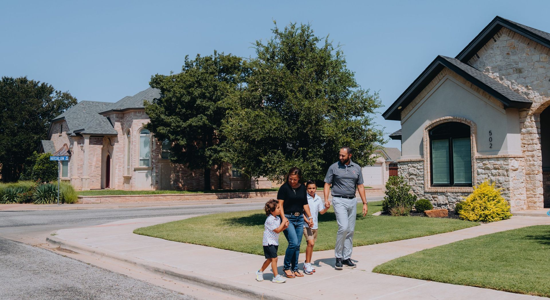 A couple outside their new home with a Texas Tech Credit Union loan officer
