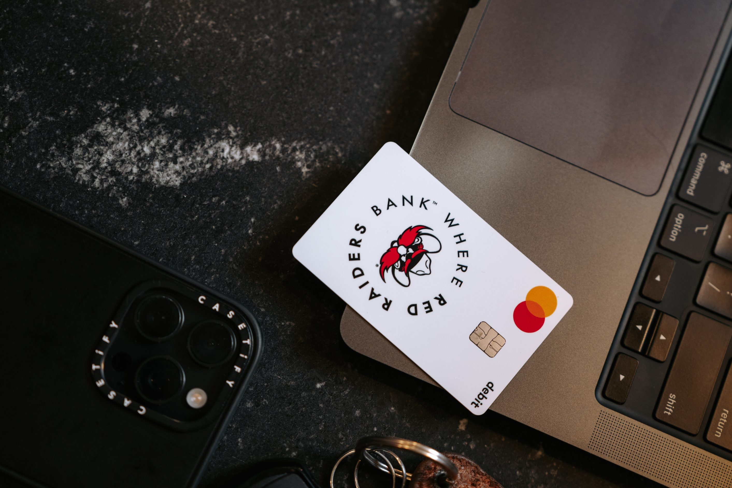 Texas Tech Credit Union Red Raiders debit card resting on a laptop keyboard