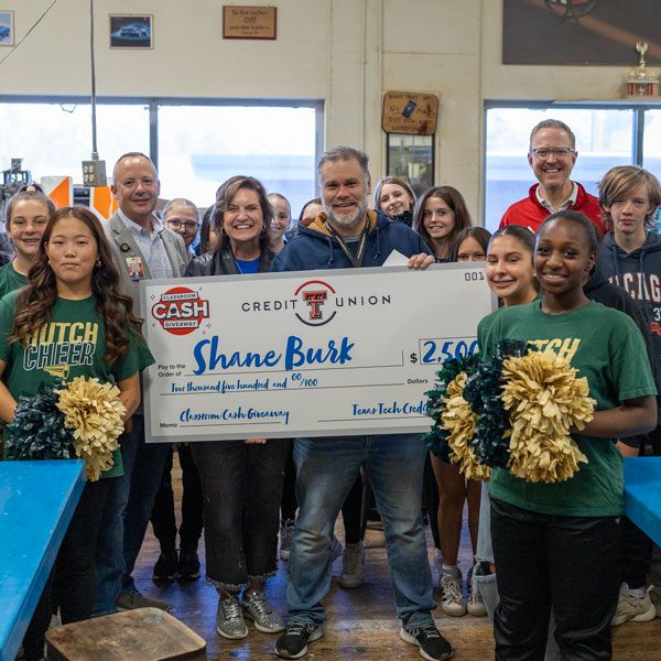 Mr. Shane Burk holding his $2,500 Classroom Cash check with his students