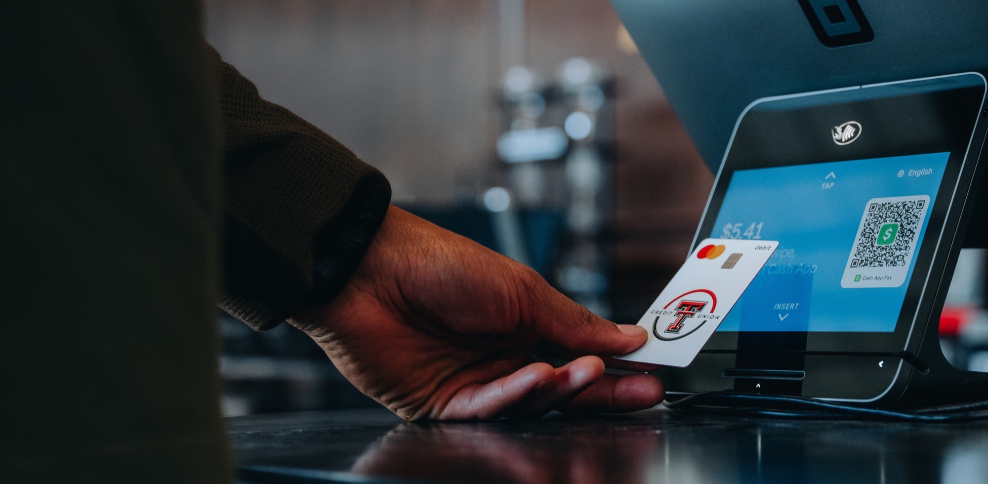 Member tapping a Texas Tech Credit Union card at a payment terminal