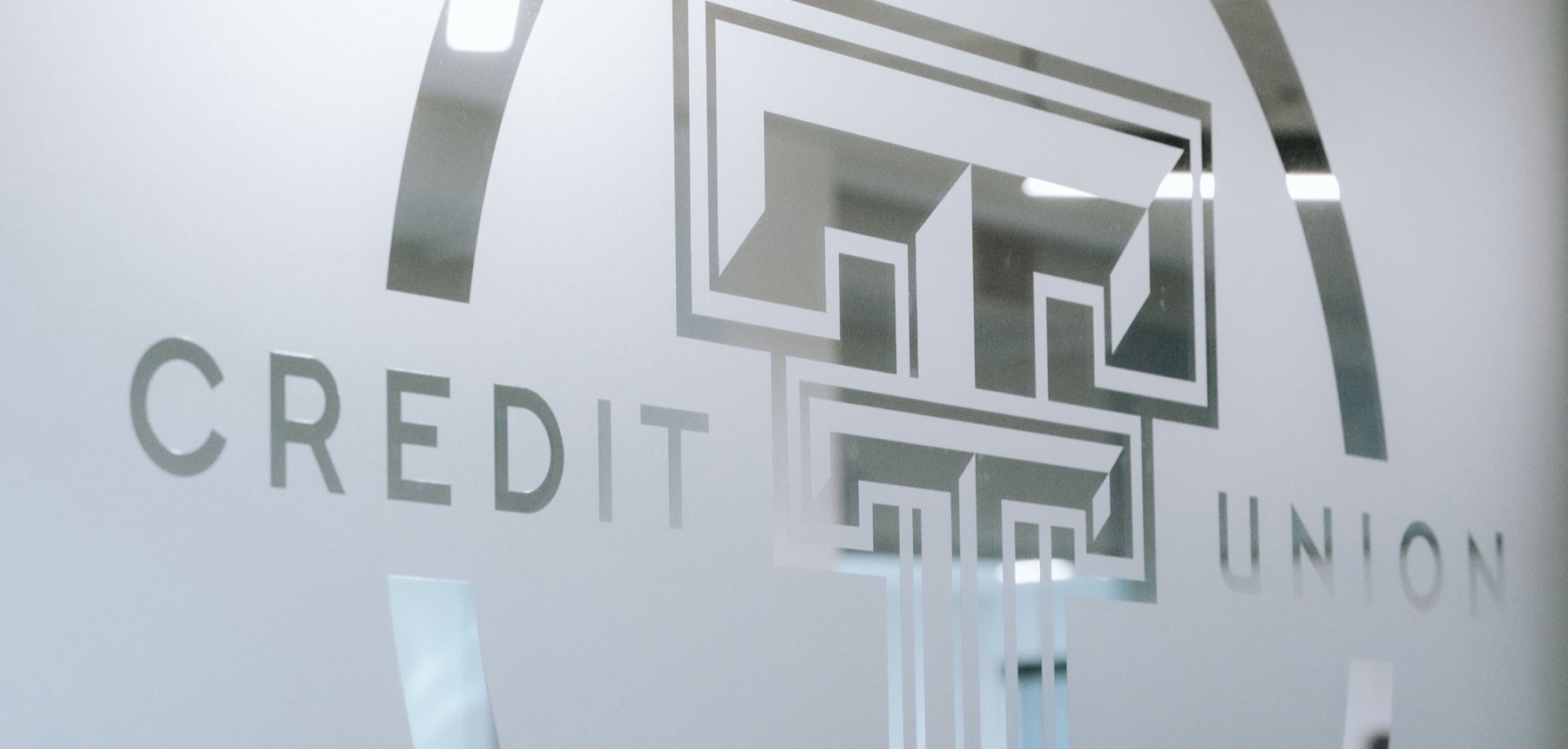Etched Texas Tech Credit Union logo on a glass wall