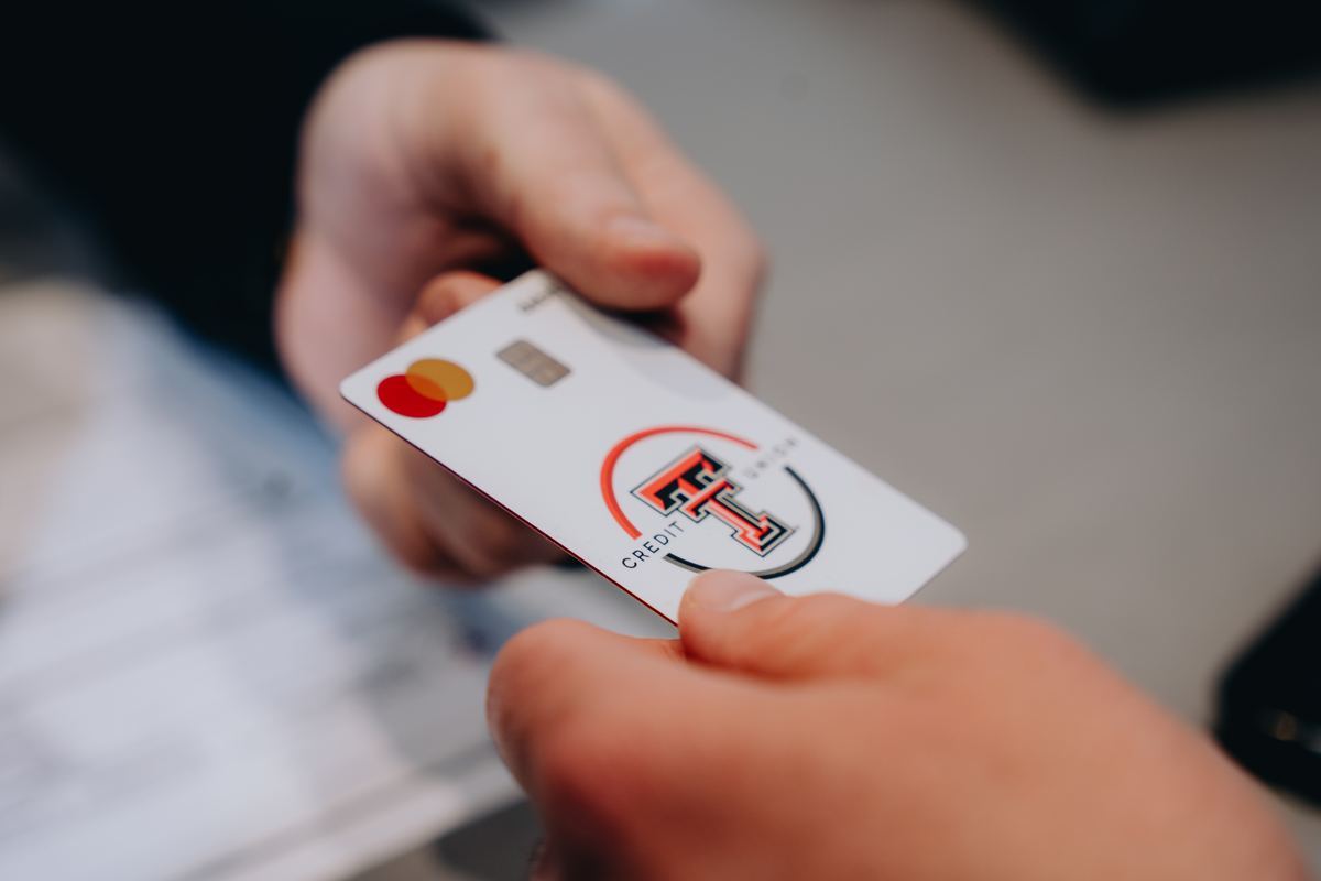Hand holding a Texas Tech Credit Union debit card