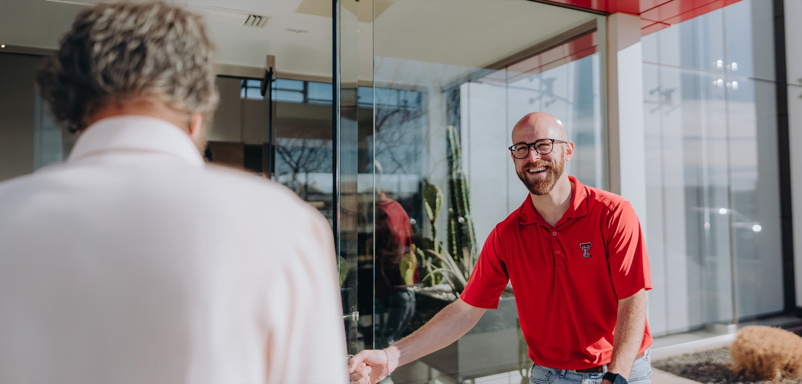 Smiling Texas Tech Credit Union member in a red polo